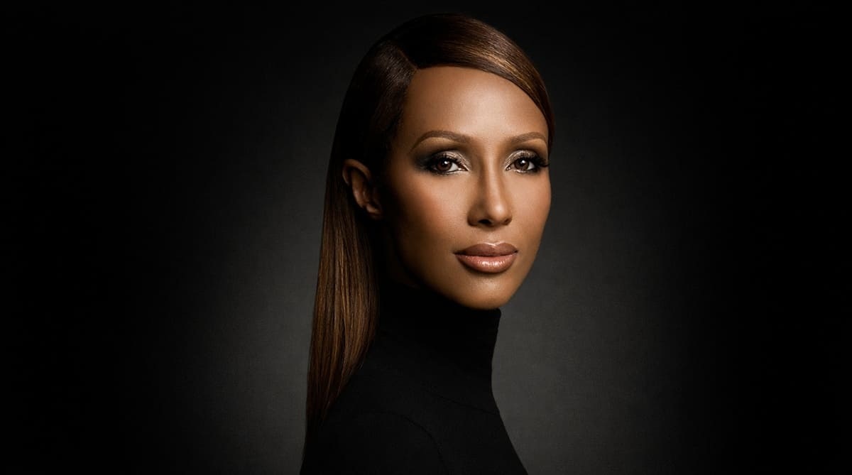 Iman Mohamed Abdulmajid in black turtleneck, professional studio portrait with gradient lighting, founder of IMAN Cosmetics